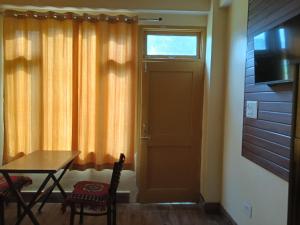 a dining room with a table and a door with a window at Divine homestay in Kukri Ser