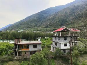 an old house in a field with a mountain at Divine homestay in Kukri Ser