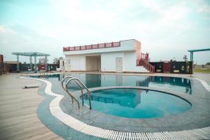 a large swimming pool in front of a building at Infinity Hotel & Resort, Chikani , Alwar in Alwar