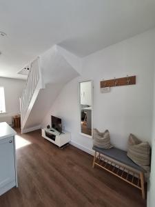 a living room with a couch and a staircase at Woodpeckers Annexe in Gosfield in Gosfield