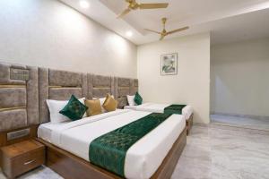 a bedroom with two beds and a ceiling fan at Hotel Shumo Grand Khammam in Khammam