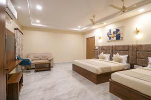 a hotel room with two beds and a chair at Hotel Shumo Grand Khammam in Khammam +18 photos