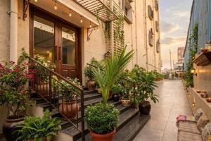 a balcony with potted plants on a building at Hotel Shumo Grand Khammam in Khammam