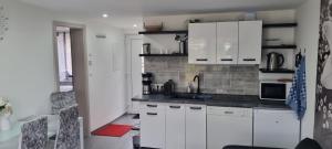 a kitchen with white cabinets and a sink at Casa Mia 36 am See in Joachimsthal