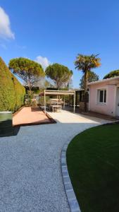 a house with a patio and a grass yard at L Atelier du zoo in Sablons