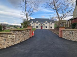 a large white house with a stone wall at Maple House Apartment in Kelso