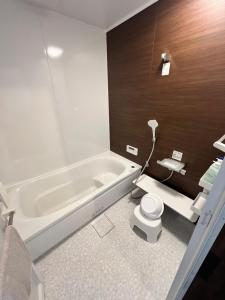 a bathroom with a bath tub and a toilet at 季紀の杜阿蘇 in Aso