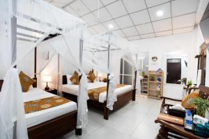 a bedroom with two beds with mosquito nets at Glamour Mirissa in Mirissa