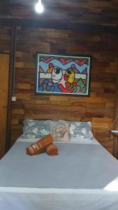 a bedroom with a bed with a painting on the wall at Casa de campo rústica 21km vila germânica Bnu in Blumenau