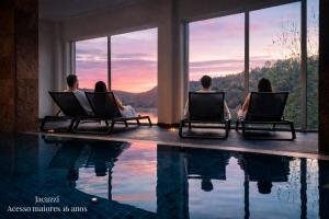 a group of people sitting in chairs next to a swimming pool at Hotel Rural Quinta da Conchada in Aguieira +88 photos