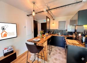 a kitchen with a wooden island in a room at La Pause de Mérimée - Jardin - Parking in Vannes