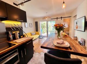 a kitchen and living room with a table with flowers on it at La Pause de Mérimée - Jardin - Parking in Vannes