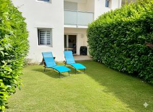 three blue chairs sitting on the grass in front of a house at La Pause de Mérimée - Jardin - Parking in Vannes +20 photos