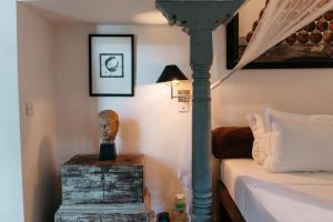 a bedroom with a bed and a table with a lamp at Boutique 87 in Bentota