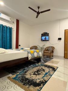 a bedroom with two beds and a ceiling fan at Vasudha Homestay in Sibsāgar