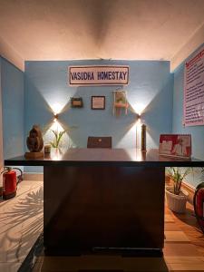 a desk in a room with a sign on the wall at Vasudha Homestay in Sibsāgar