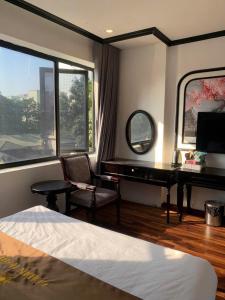a bedroom with a piano and a desk with a mirror at Golden Villa in Hanoi