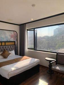 a bedroom with a bed and a chair and a window at Golden Villa in Hanoi +27 photos