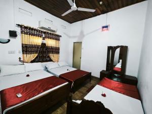 a room with two beds and a window at JP Rest House in Trincomalee