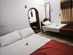 a room with two beds and a mirror at JP Rest House in Trincomalee +5 photos