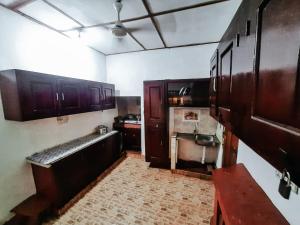 a kitchen with dark wooden cabinets and a counter top at JP Rest House in Trincomalee
