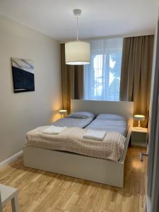 a bedroom with a bed and a large window at Sóstó Liget House in Igricetanya