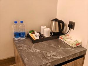 a counter with two bottles of water and a kettle at Hotel Grand Pacific in Cox's Bazar