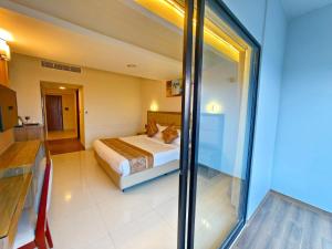 a bedroom with a bed and a large glass window at Hotel Grand Pacific in Cox's Bazar +51 photos