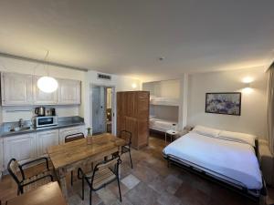 a kitchen and a bedroom with a bed and a table at Alpesmith - Bike & Ski apartments in Bardonecchia