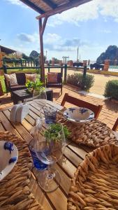 a wooden table with plates and wine glasses on it at Aligia Chalet in Nebida