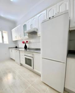 a kitchen with white cabinets and a white refrigerator at Casa de Silvia in Arrecife