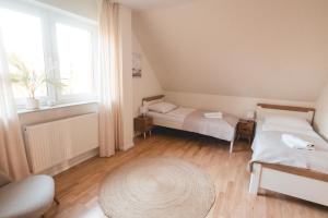 a small room with two beds and a window at Ferienhaus FachWerkPerle am Alfsee in Rieste +22 photos