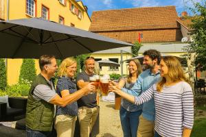 a group of people holding up glasses of beer at Speidel´s BrauManufaktur in Ödenwaldstetten