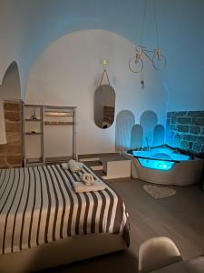 a bedroom with a bed and a tub in it at Marbella house con jacuzzi in Polignano a Mare +7 photos
