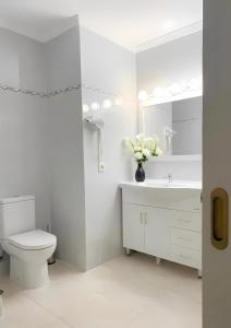 a white bathroom with a toilet and a sink at Casa de Silvia in Arrecife +15 photos