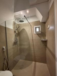 a bathroom with a shower with a glass door at Marbella house con jacuzzi in Polignano a Mare