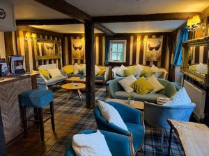 a living room with couches and chairs and tables at The Hole In The Wall in Little Wilbraham