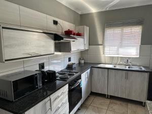 a kitchen with a microwave and a stove top oven at Waterfall Deluxe in Rustenburg