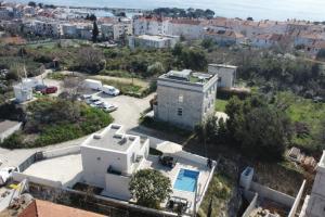 an aerial view of a white house with a pool at Villa RoseMary in Split