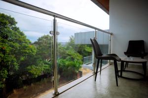 a balcony with a chair and a large window at Buffalo Village in Kigali