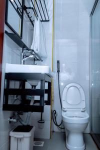a bathroom with a white toilet and a sink at Buffalo Village in Kigali +69 photos