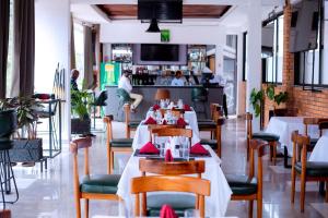 a restaurant with tables and chairs and a bar at Buffalo Village in Kigali