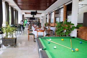 a pool table in a restaurant with tables and chairs at Buffalo Village in Kigali