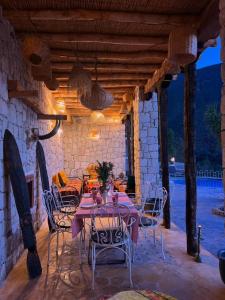 a dining table and chairs on a patio at KASBAH LA DAME BIJA in Ouirgane