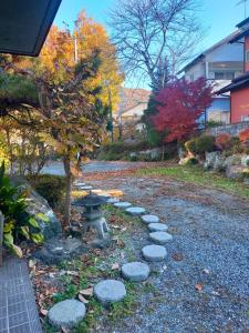 a stone path with a picnic table and a tree at Suijinhotel in Tochiya