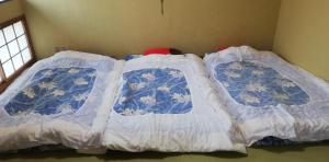 two beds in a room with blue and white sheets at Suijinhotel in Tochiya