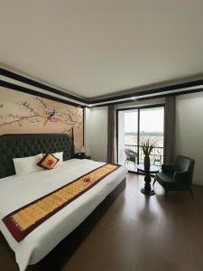 a bedroom with a large bed and a chair at Sunrise Villa Hanoi in Hanoi