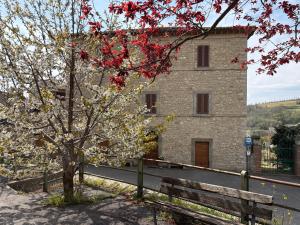 a building with a tree next to a fence at Il Palazzo del Borgo - Affittacamere in Todi +46 photos