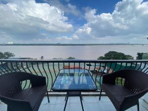 a table and chairs on a balcony with a view of the water at Sunrise Villa Hanoi in Hanoi