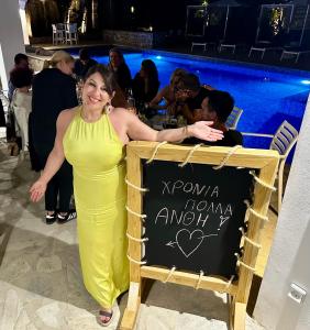 a woman in a yellow dress standing next to a sign at Villa K Boutique Hotel, Kommeno Limni in Kommeno +183 photos